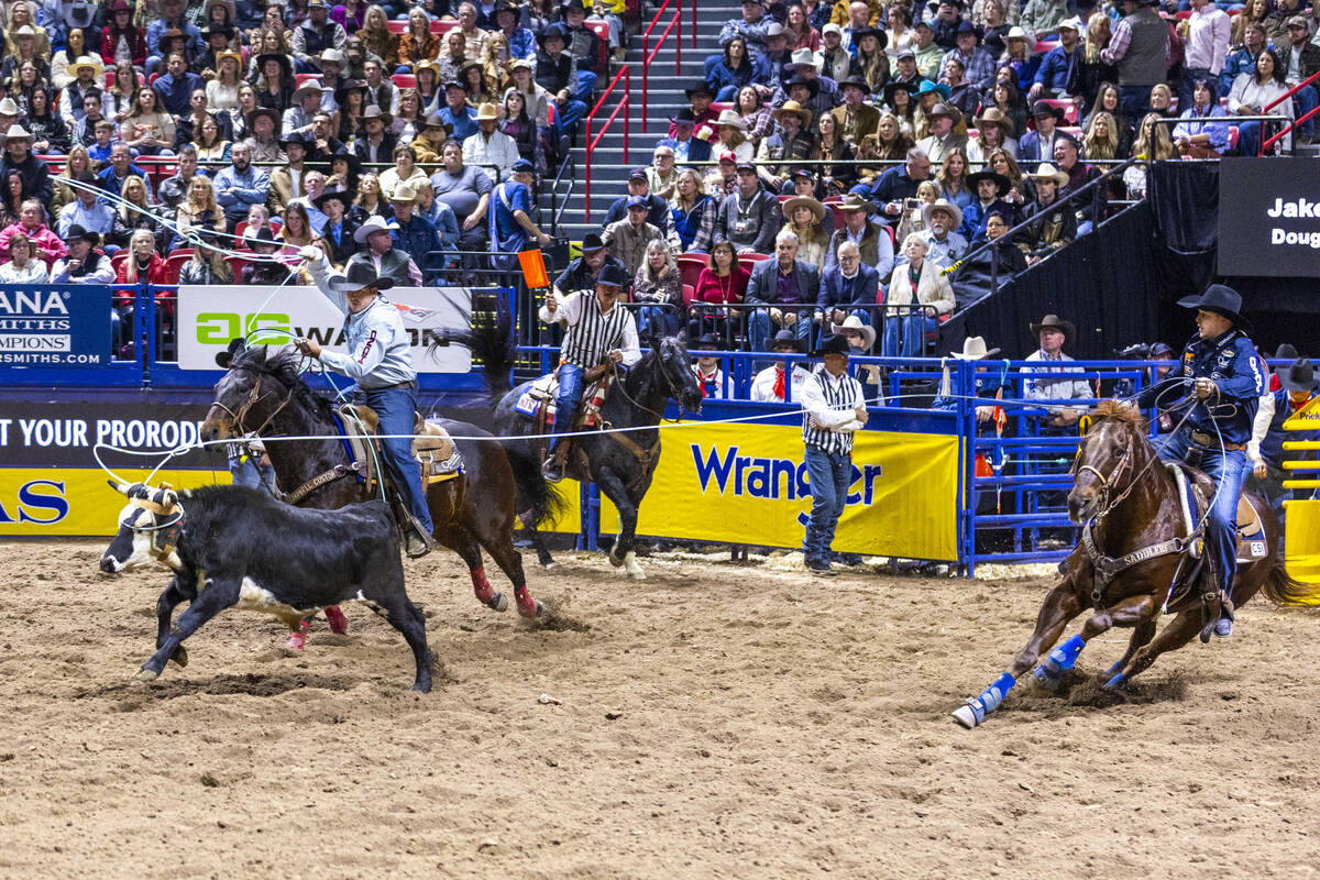 Heeler Douglas Rich, left, and header Jake Smith work to tope their calf for a win in Team Ropi ...