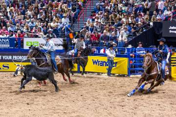 Heeler Douglas Rich, left, and header Jake Smith work to tope their calf for a win in Team Ropi ...