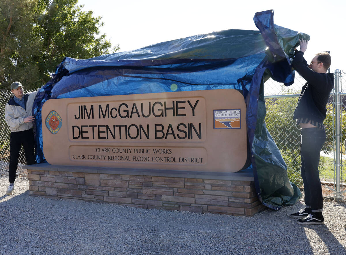Cody McMcGaughey, left, and his brother Collin, grandsons of Jim McGaughey, unveil a sign as th ...
