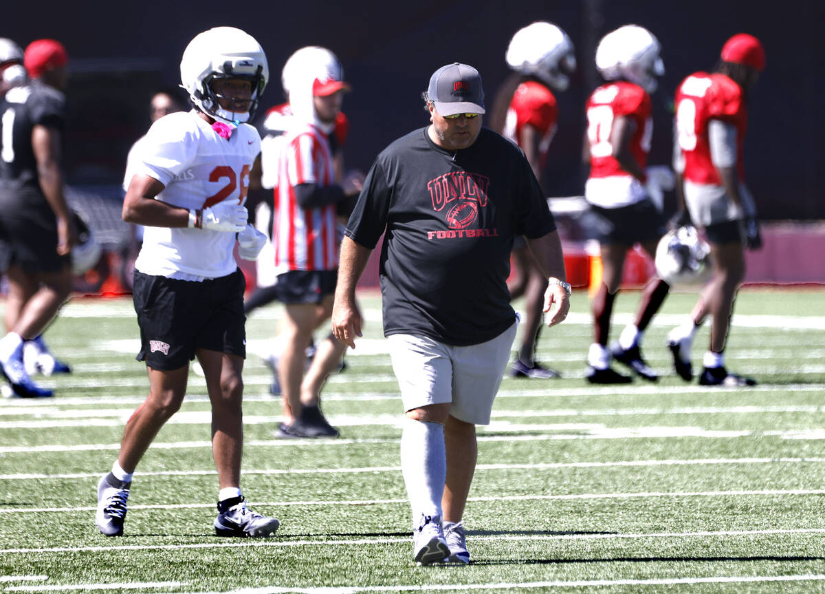 UNLV football interim defensive coordinator Paul Guenther, right, takes the field with his play ...