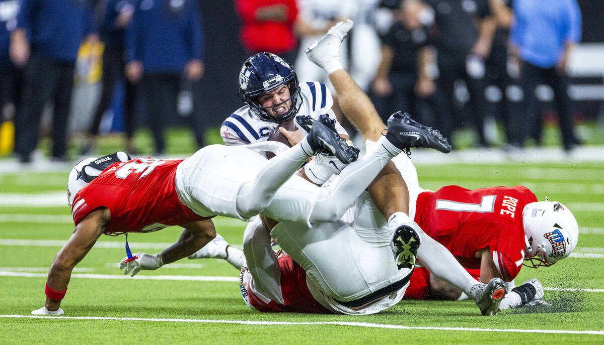 Utah State Aggies quarterback Bryson Barnes (16) team tackled by UNLV defenders in overtime of ...