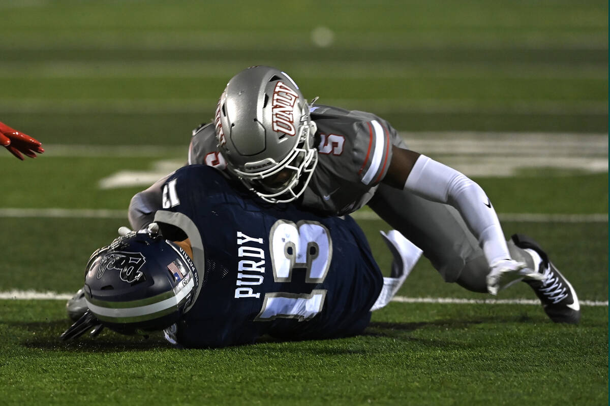 UNLV's Quandarius Keyes tackles Chubba Purdy as he carried the ball for Nevada during the ...