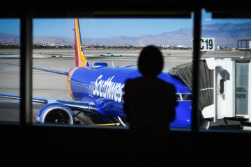 A passenger looks out at a Southwest Airlines jet Saturday, June 14, 2025, at Harry Reid Intern ...