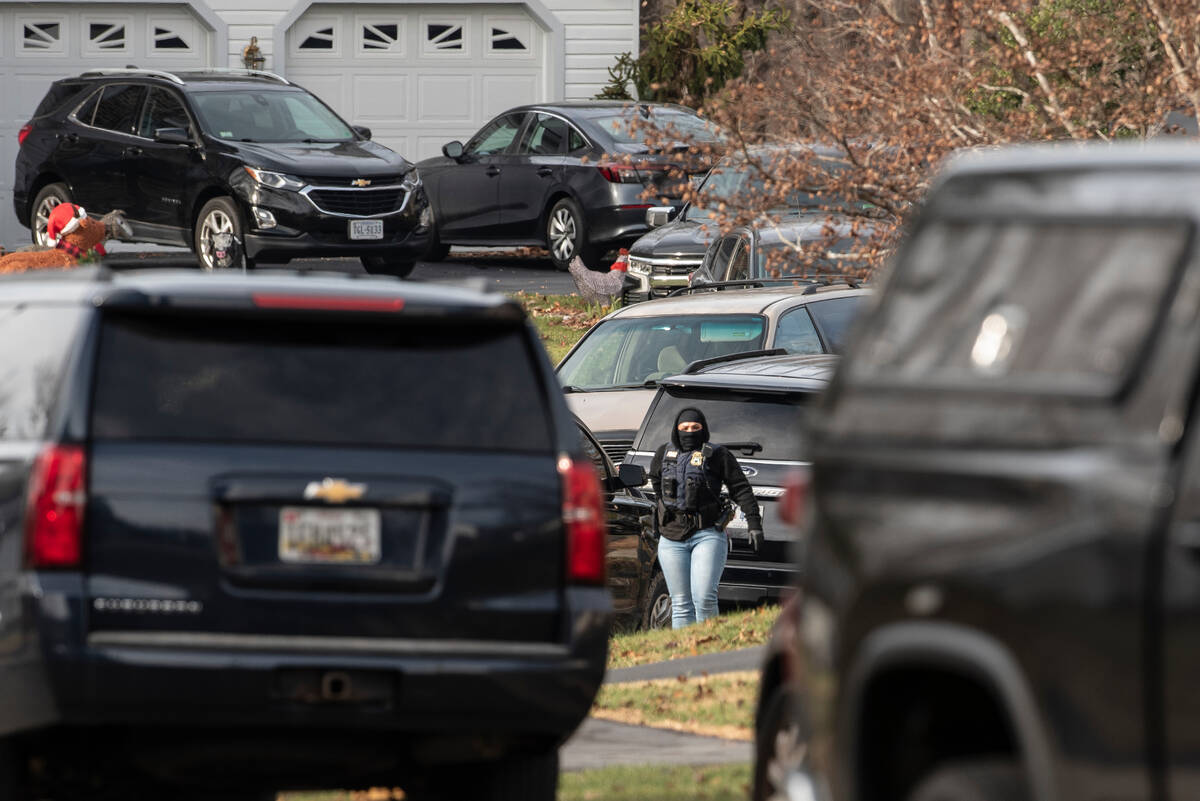 An FBI agent stands near the house where the FBI made an arrest, in Woodbridge, Va., Thursday, ...