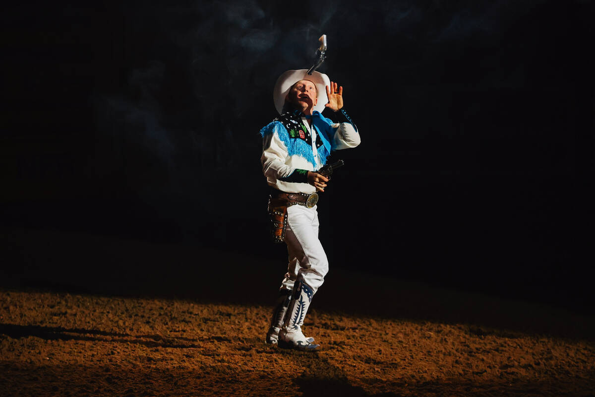 A cowboy tosses a gun in the air during day three of the National Finals Rodeo at the Thomas &a ...