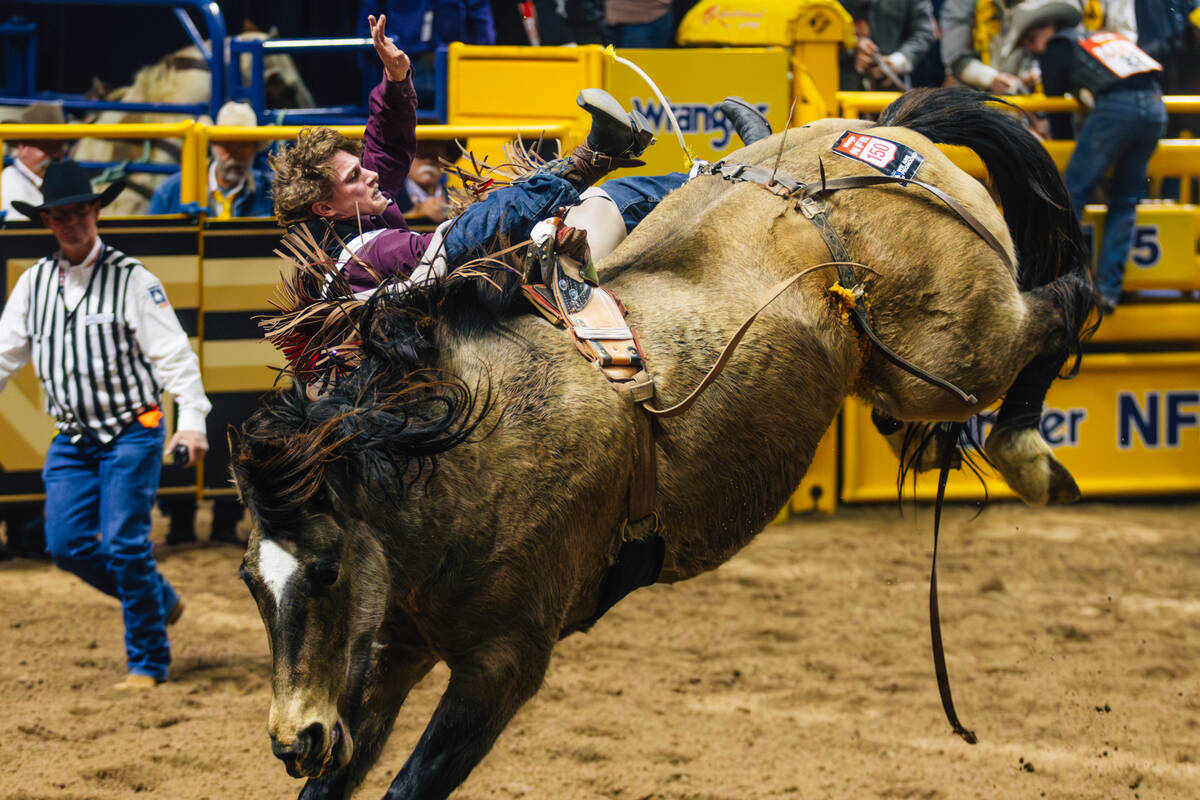 Cooper Cooke falls off of Straight Ringer during day three of the National Finals Rodeo at the ...