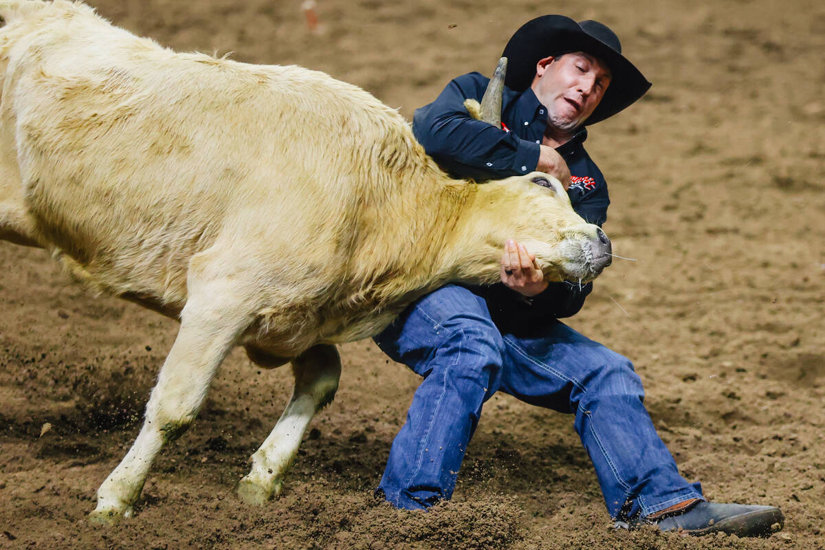 Scott Guenthner wrestles the steer during day three of the National Finals Rodeo at the Thomas ...