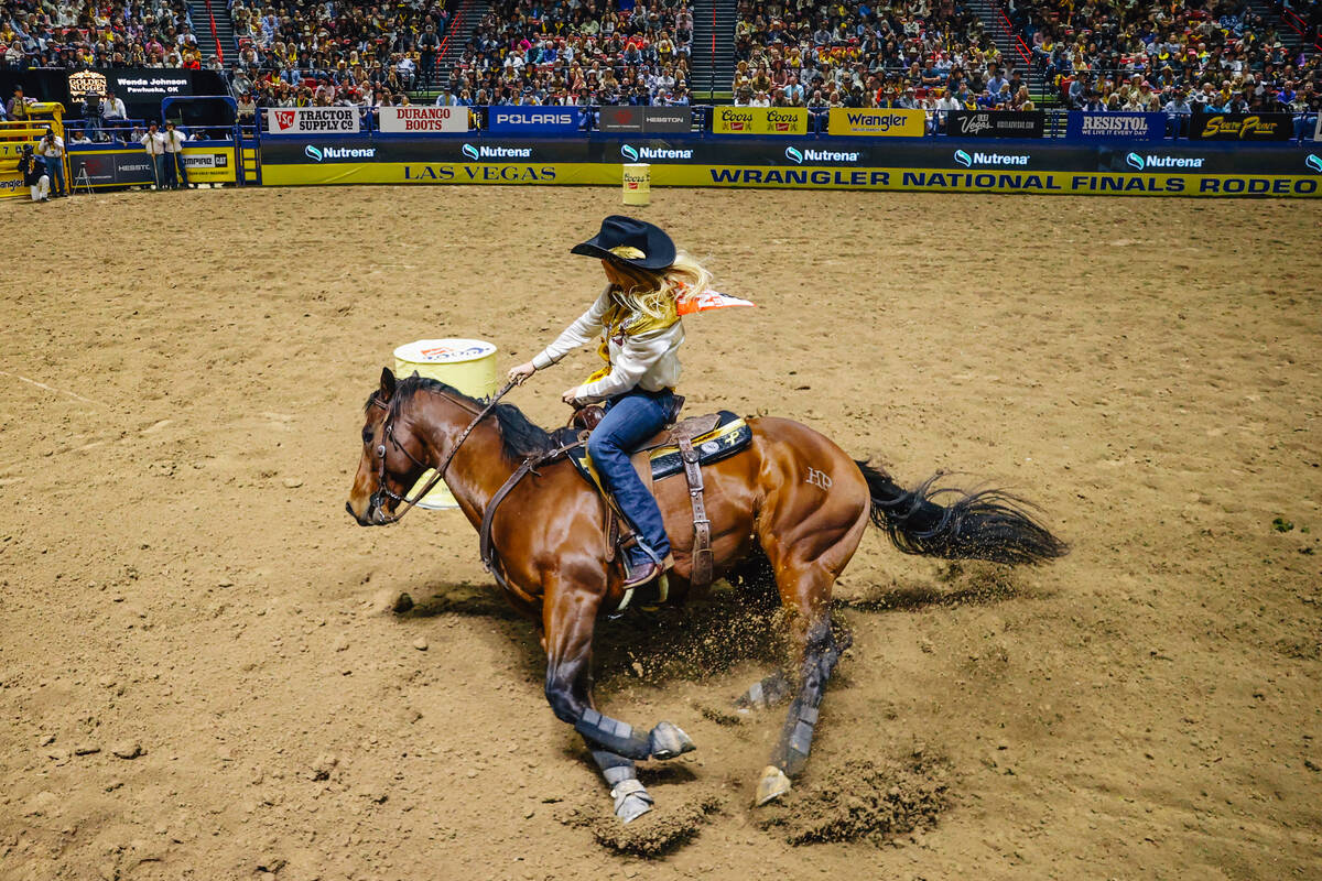 Wenda Johnson rides around the first barrel during day three of the National Finals Rodeo at th ...