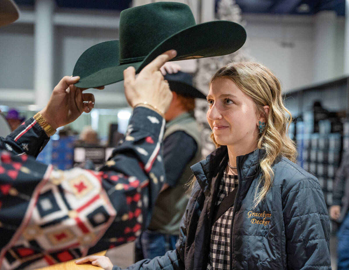 Gracelynn Decker tries on her hat after it was personally fitted for her during Cowboy Christma ...