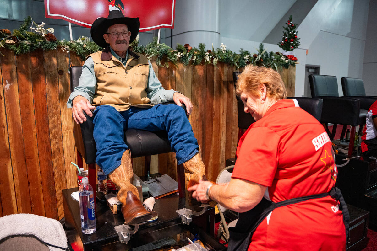 Don Moss from Oregon gets his boots shinned during Cowboy Christmas at the Las Vegas Convention ...