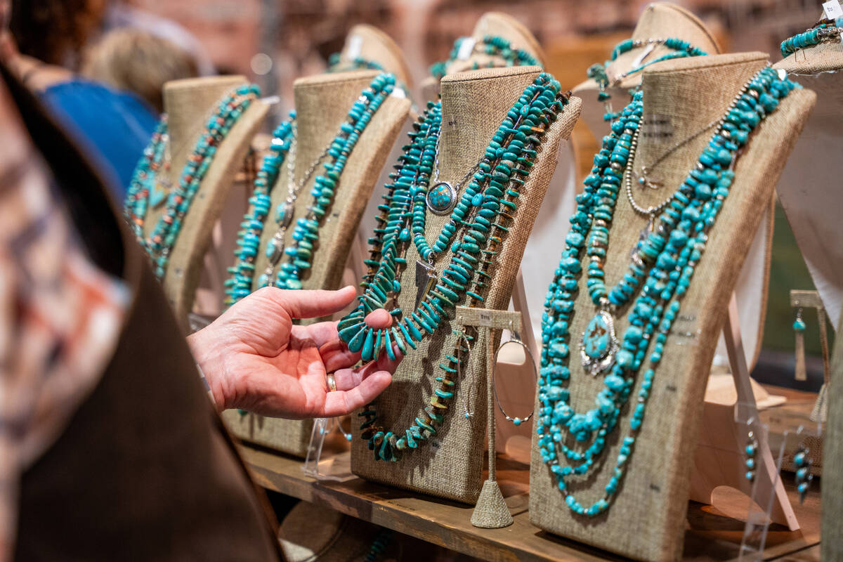 A customer checks out a turquoise necklace during Cowboy Christmas at the Las Vegas Convention ...