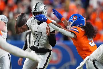 Las Vegas Raiders quarterback Geno Smith (7) is sacked by Denver Broncos safety Talanoa Hufanga ...