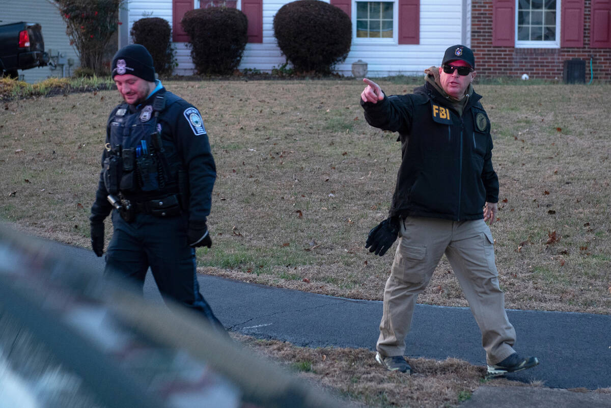 A FBI explosive ordnance agent talks with a Prince William County Police officers as agents inv ...