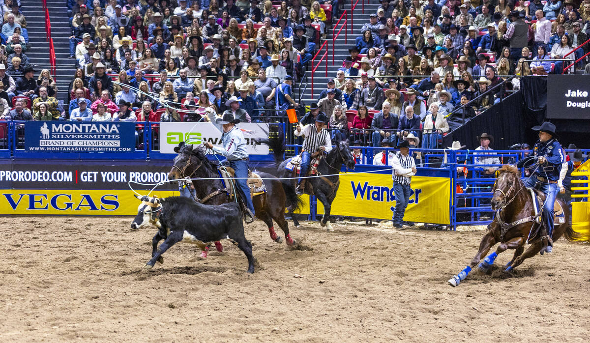 Heeler Douglas Rich, left, and header Jake Smith work to tope their calf for a win in Team Ropi ...