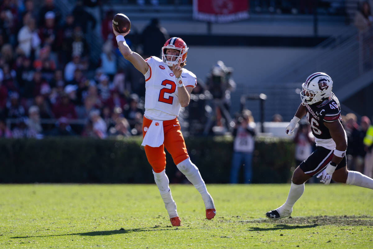 Clemson quarterback Cade Klubnik (2) throws on the run from South Carolina defensive end Bryan ...