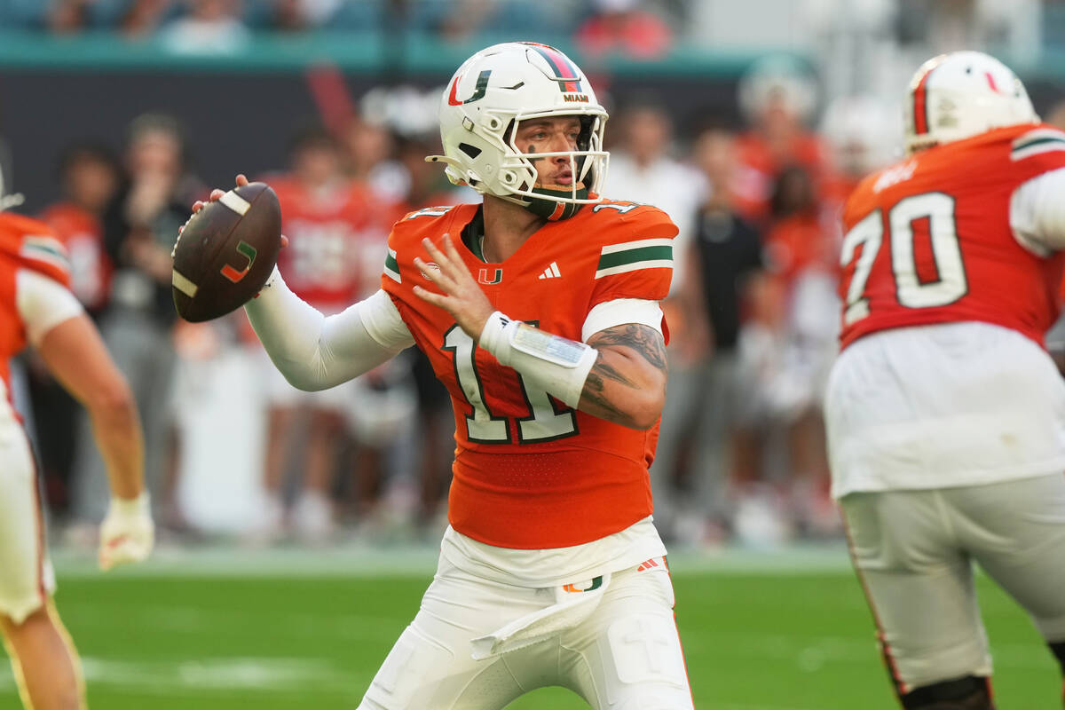 Miami quarterback Carson Beck (11) aims a pass during the first half of an NCAA college footbal ...