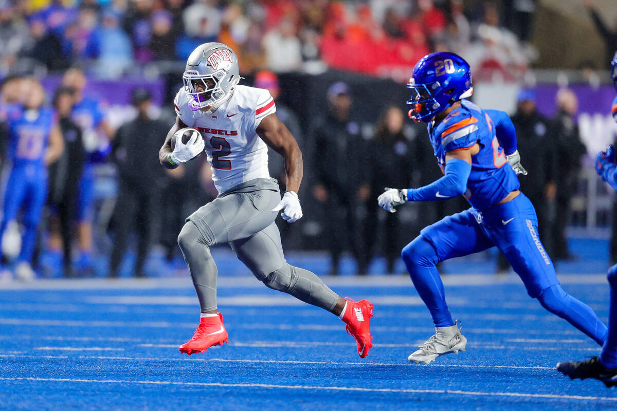 UNLV running back Keyvone Lee (2) runs from Boise State cornerback Jaden Mickey on a run in the ...