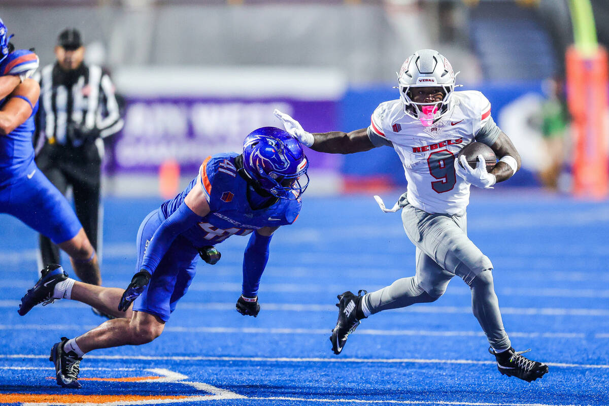 UNLV running back Jai'Den Thomas (9) stiff-arms Boise State linebacker Boen Phelps, second ...