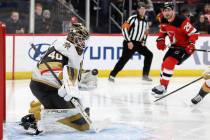 Vegas Golden Knights goaltender Akira Schmid, left, makes a save during the second period of a ...