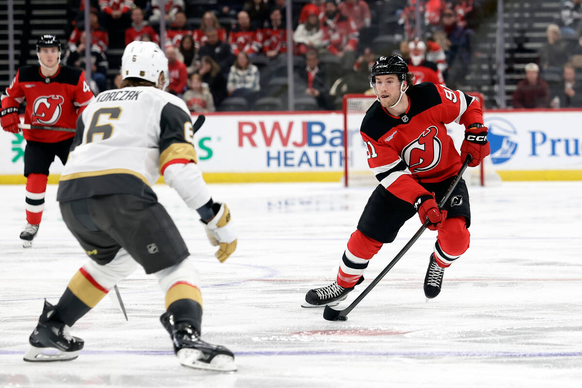 New Jersey Devils center Dawson Mercer (91) controls the puck past Vegas Golden Knights defense ...