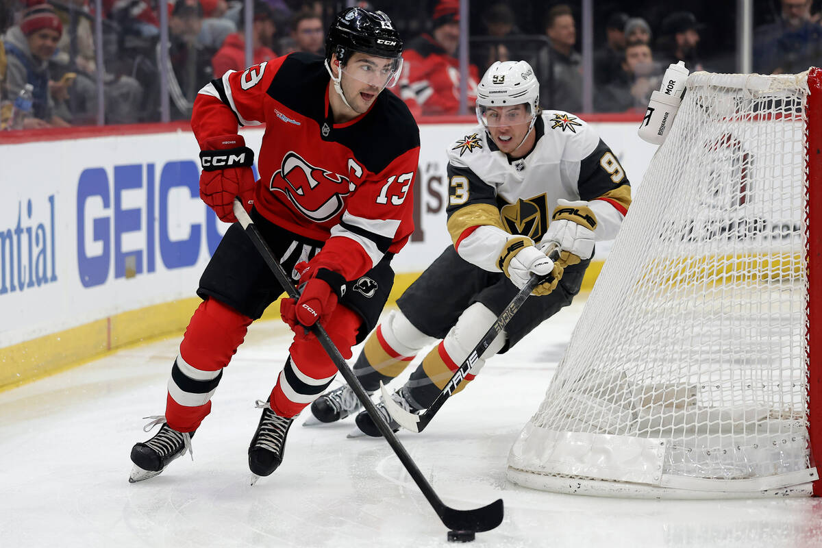 New Jersey Devils center Nico Hischier (13) controls the puck past Vegas Golden Knights right w ...