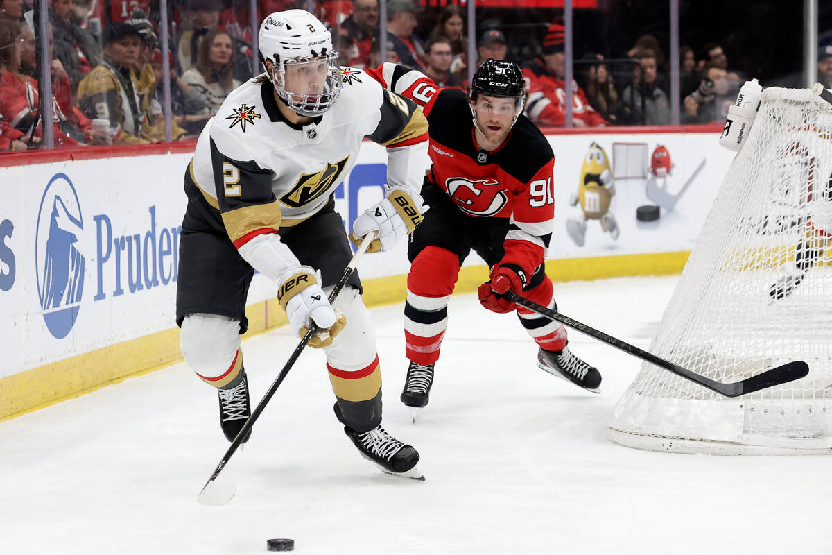 Vegas Golden Knights defenseman Zach Whitecloud (2) controls the puck past New Jersey Devils ce ...