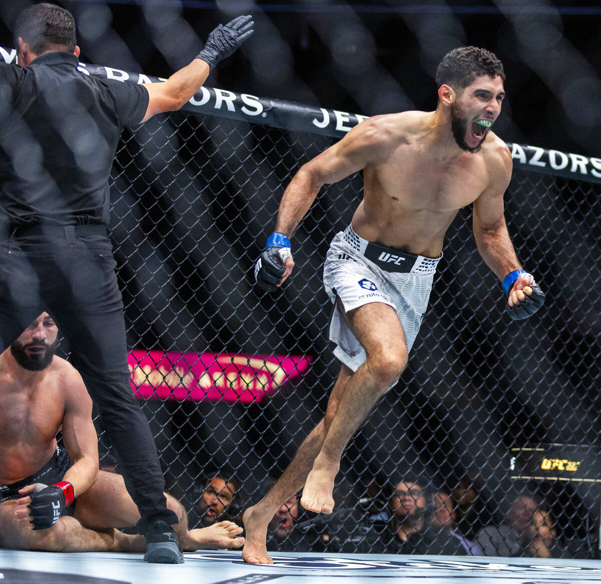 Nazim Sadykhov is down on the canvas as Farés Ziam celebrates his win following their ligh ...