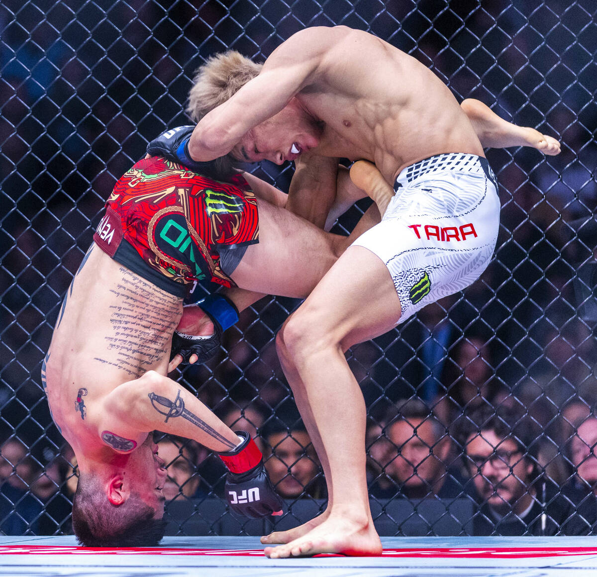 Brandon Moreno is driven onto his head as Tatsuro Taira works for position during their flyweig ...