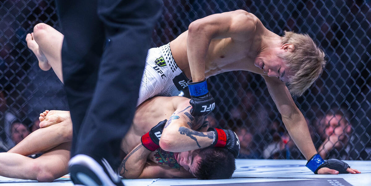 Tatsuro Taira sends punches down to the head of Brandon Moreno during their flyweight fight in ...