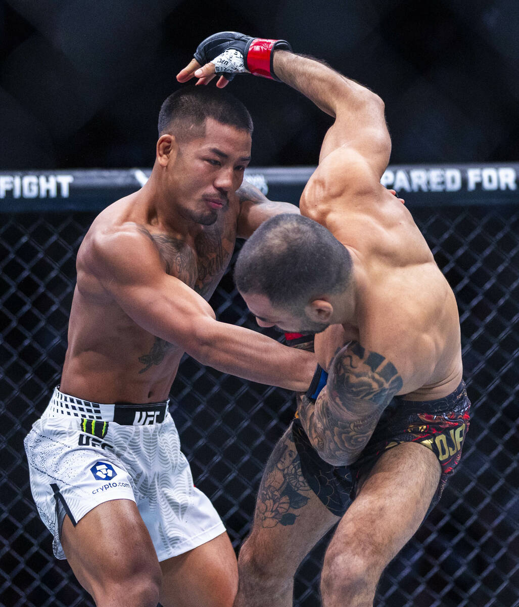 Joshua Van connects with a shot to the body of Alexandre Pantoja during their flyweight title f ...