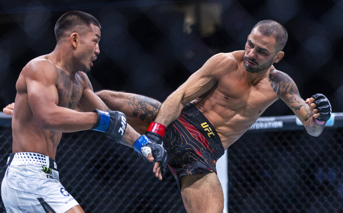 Joshua Van takes a shot to the body from Alexandre Pantoja during their flyweight title fight i ...