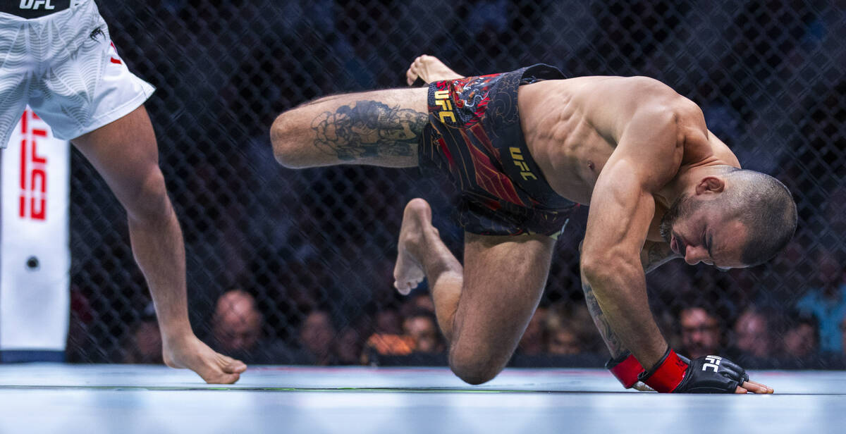 Alexandre Pantoja breaks his arm as he lands badly on the canvas after being upended by Joshua ...