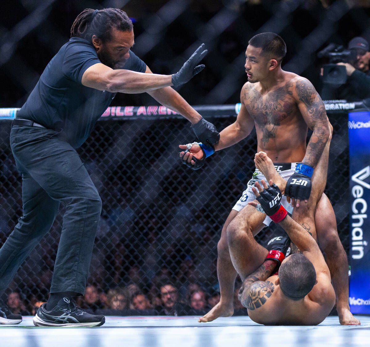 The referee ends the fight for Joshua Van as Alexandre Pantoja is injured on the canvas during ...