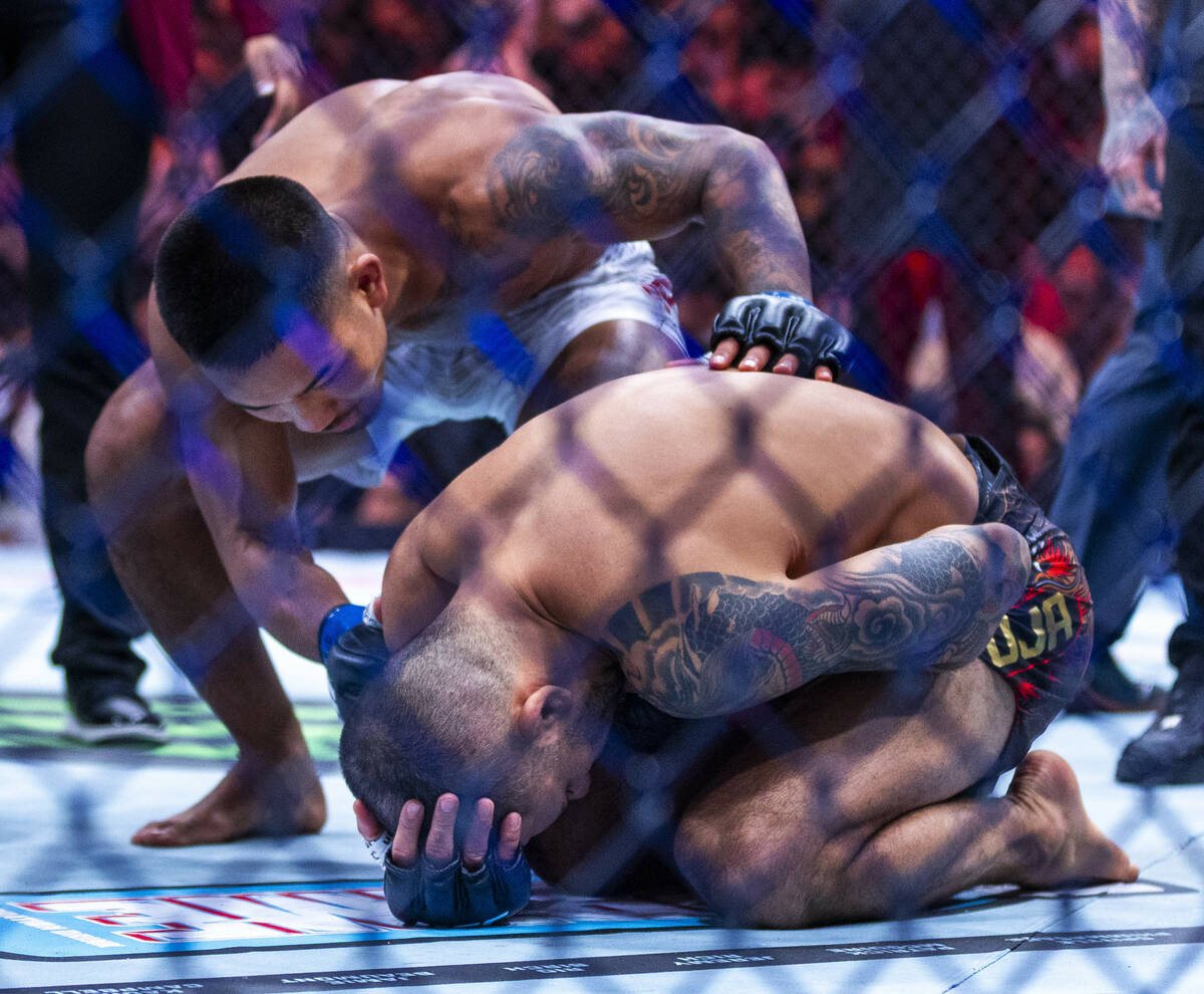 Alexandre Pantoja is comforted by Joshua Van after losing to an arm injury during their flyweig ...