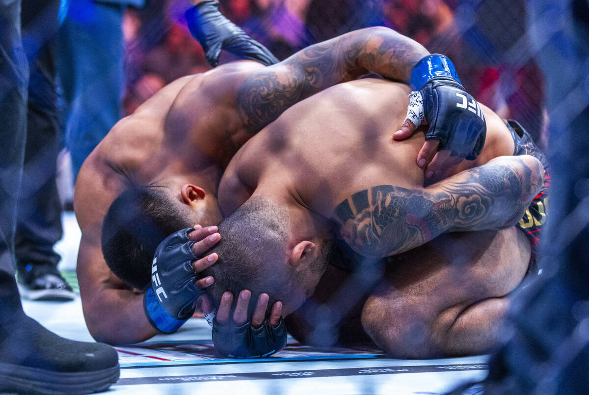 Alexandre Pantoja is comforted by Joshua Van after losing to an arm injury during their flyweig ...