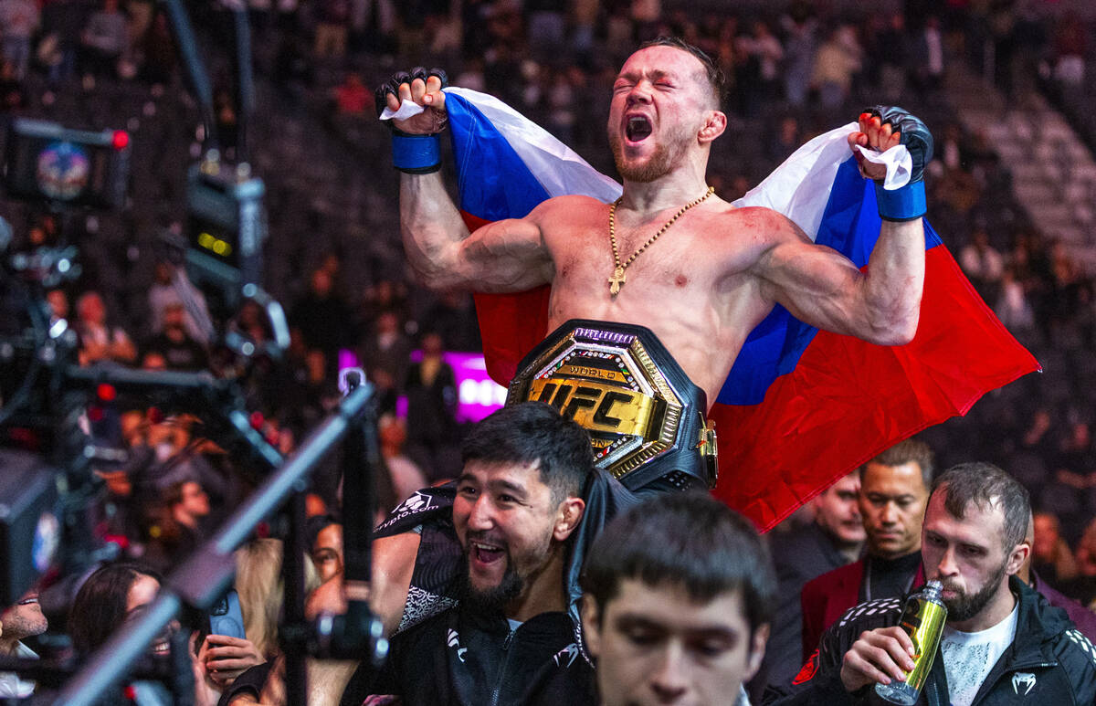 Petr Yan is carried from the octagon with his new belt after defeating Merab Dvalishvili during ...