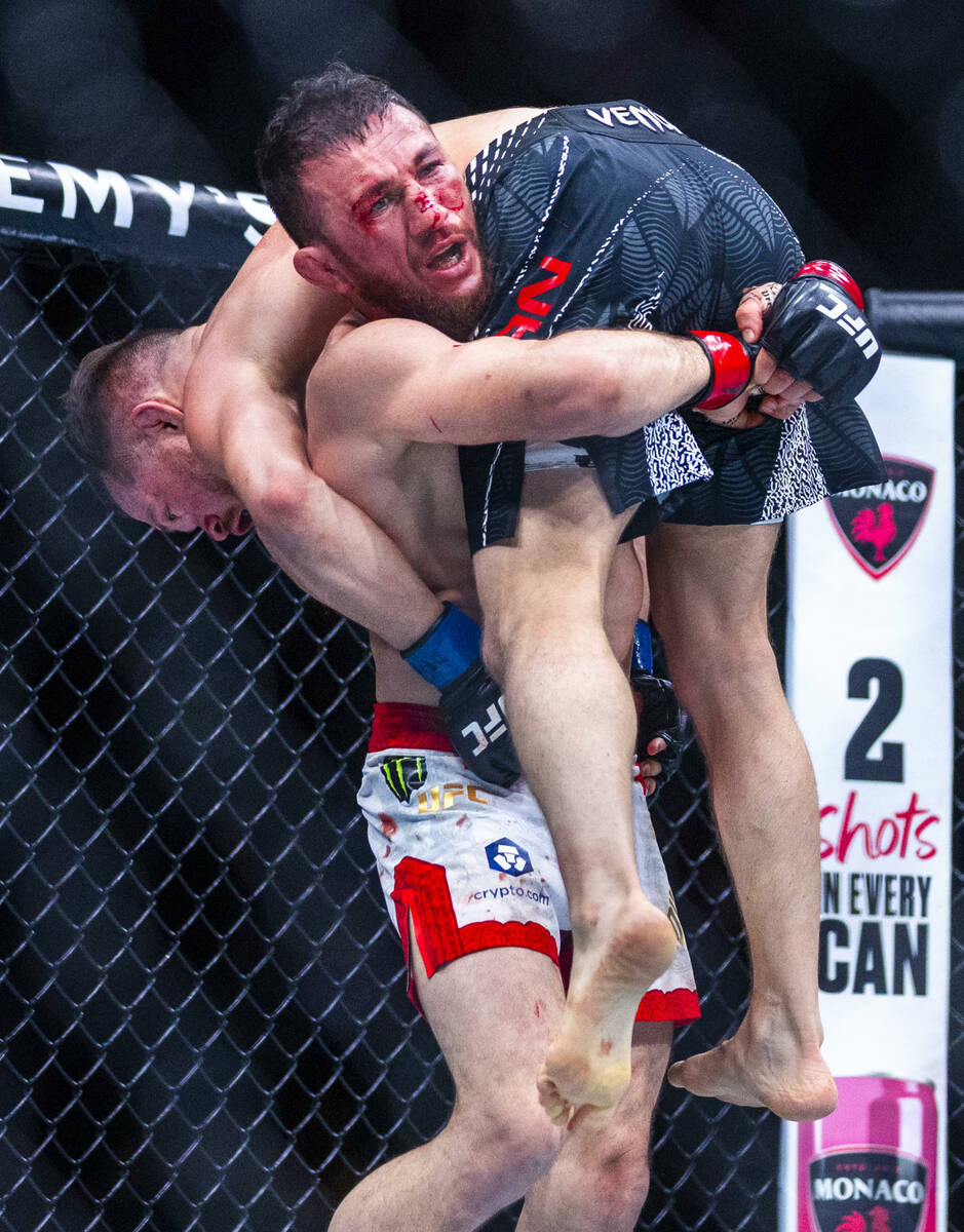 Merab Dvalishvili lifts up Petr Yan before driving him down to the canvas during their bantamwe ...