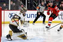 Vegas Golden Knights goaltender Akira Schmid, left, makes a save during the second period of an ...