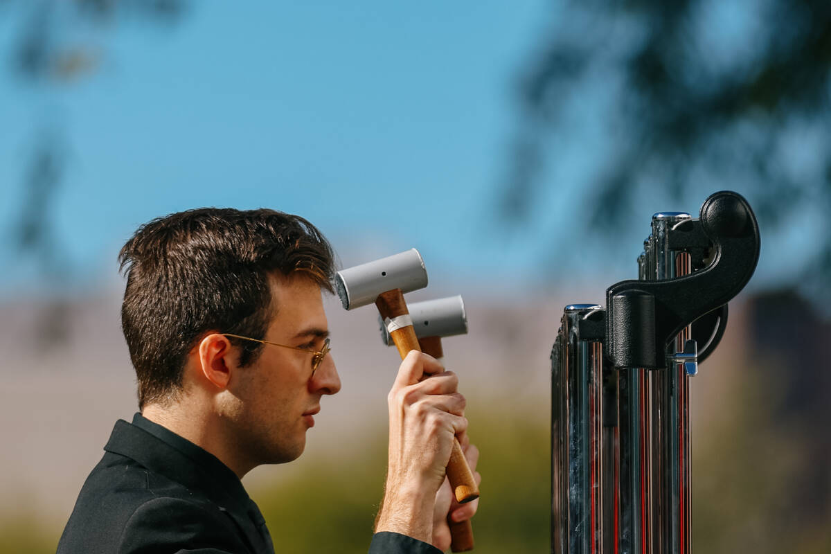 Sam Wetzel, DMA Candidate in percussion at the School of Music, rings the memorial chimes three ...