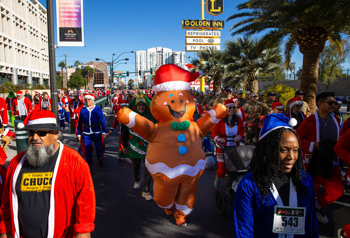 Attendees make their way down Las Vegas Boulevard during the 21st annual Great Santa Run on Sat ...