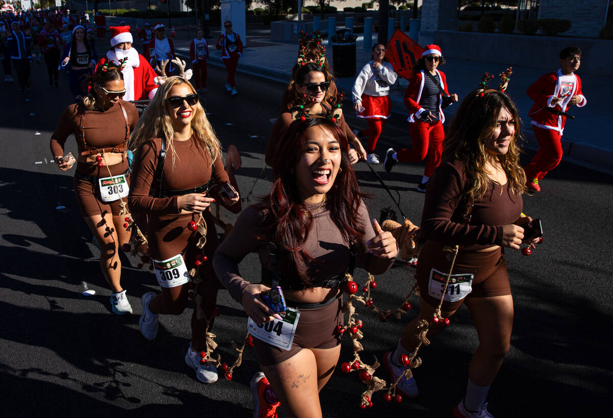 Participants dressed as reindeer make their way down Las Vegas Boulevard during the 21st annual ...