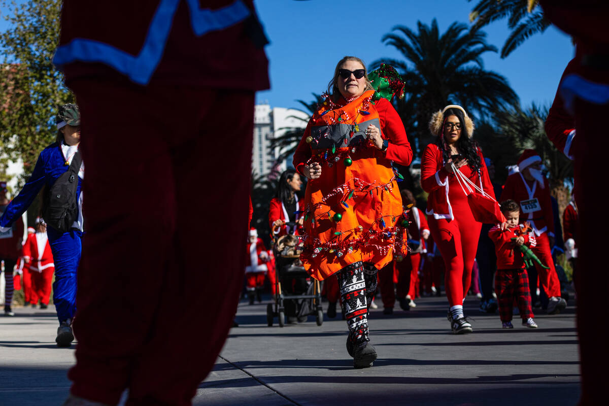 Attendees make their way down Las Vegas Boulevard during the 21st annual Great Santa Run on Sat ...