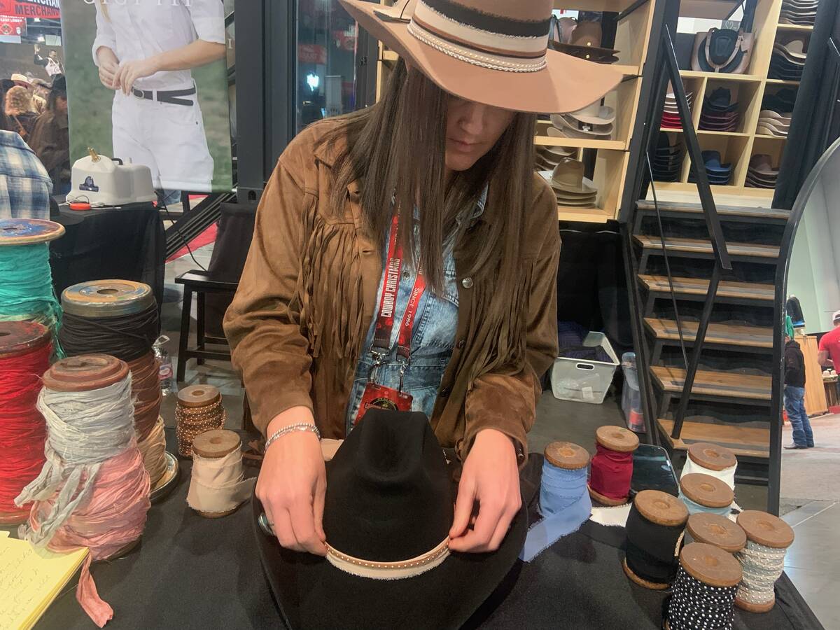 Jake Winstead of Bend, Ore., tries on -- and later buys -- a pair of cowboy boots from the Aria ...
