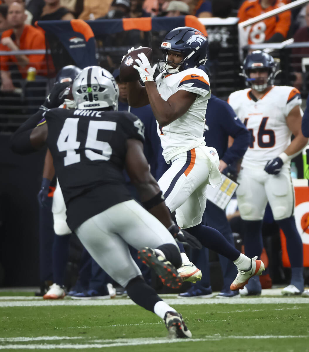Denver Broncos wide receiver Marvin Mims Jr. (19) makes the reception under pressure from Raide ...