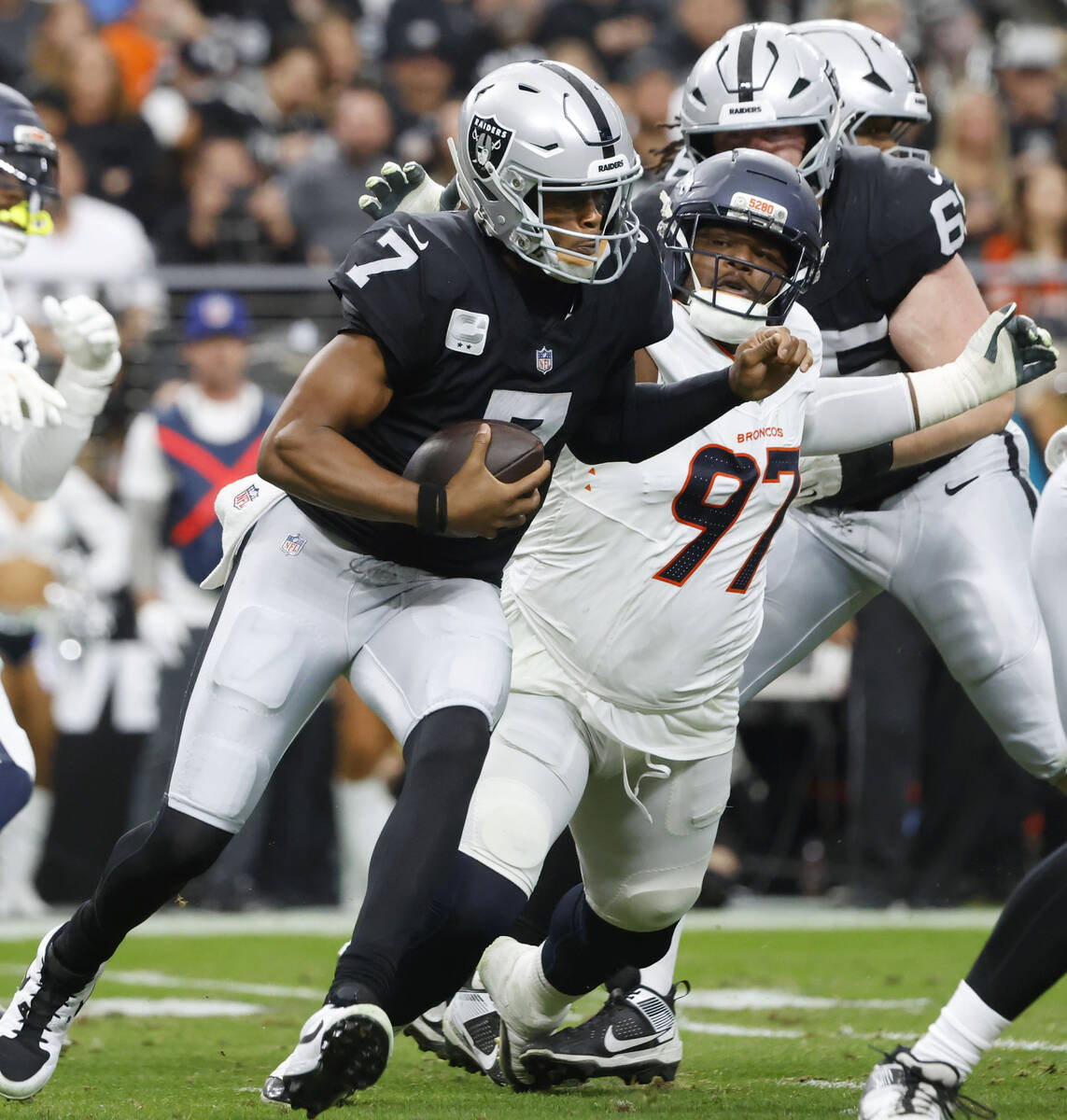 Raiders quarterback Geno Smith (7) is taken down by Denver Broncos defensive tackle Malcolm Roa ...