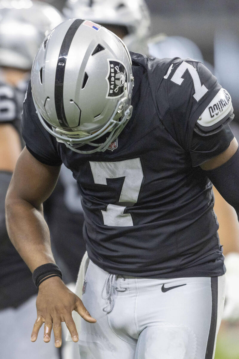 Raiders quarterback Geno Smith (7) exmaines his throwing hand after being hit during the second ...