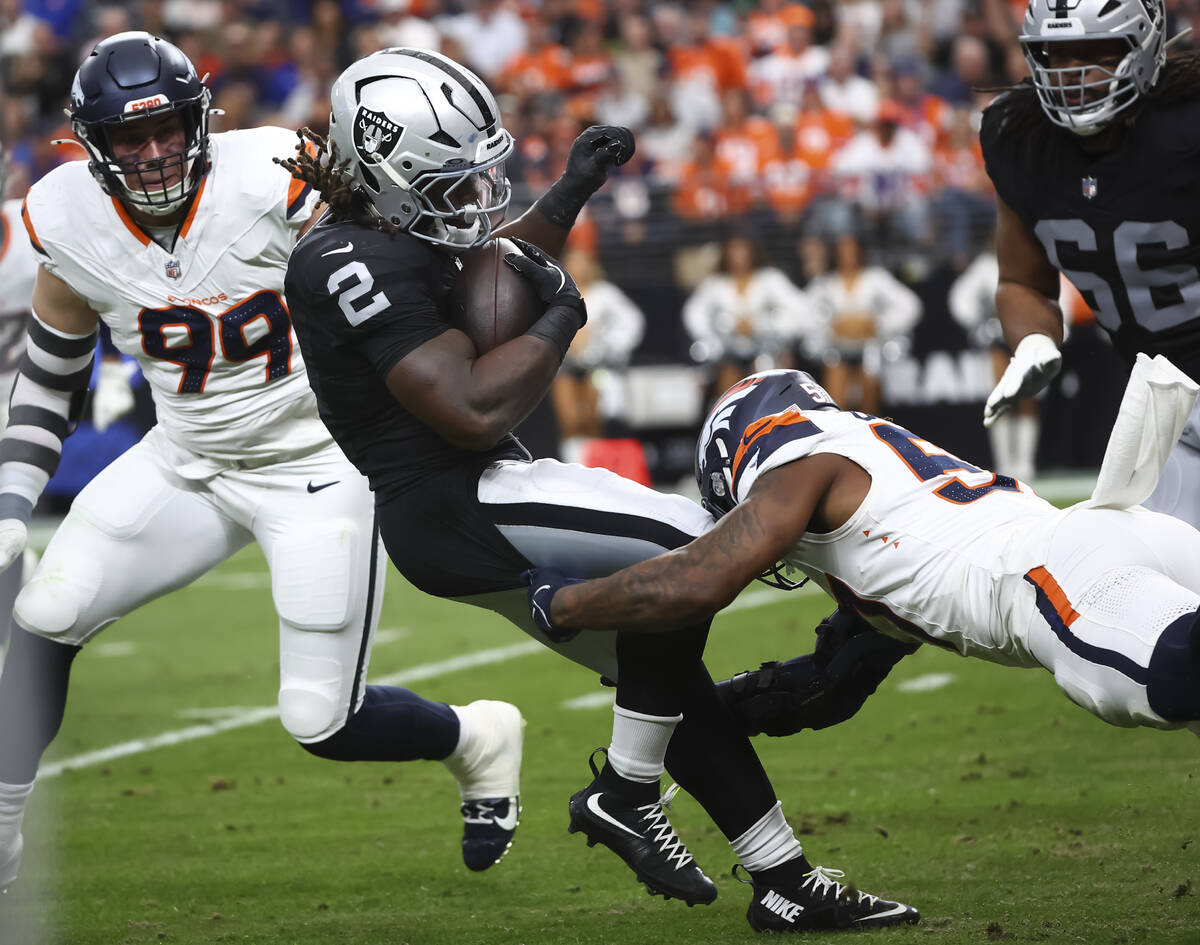 Raiders running back Ashton Jeanty (2) gets tackled by Denver Broncos linebacker Dre Greenlaw ( ...