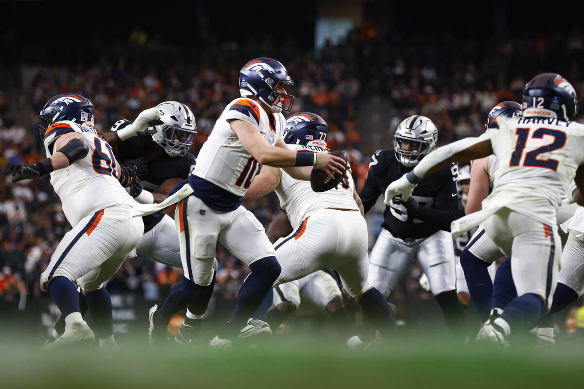 Denver Broncos quarterback Bo Nix (10) looks to hand off the ball during the second half of an ...