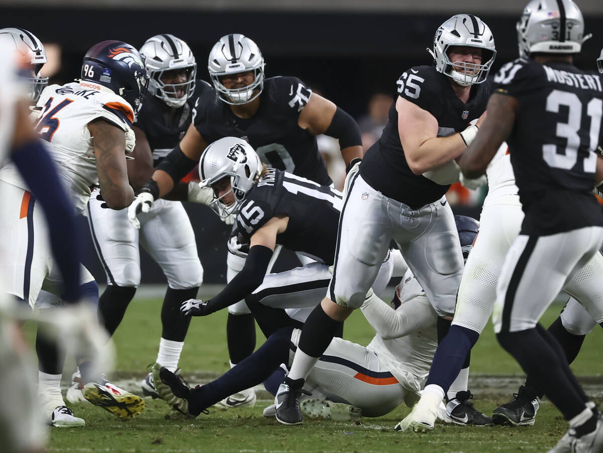 Raiders quarterback Kenny Pickett (15) gets sacked by the Denver Broncos during the second half ...