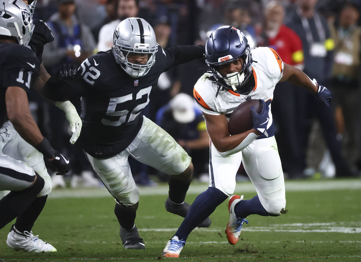 Denver Broncos running back Jaleel McLaughlin (38) runs the ball under pressure from Raiders ou ...